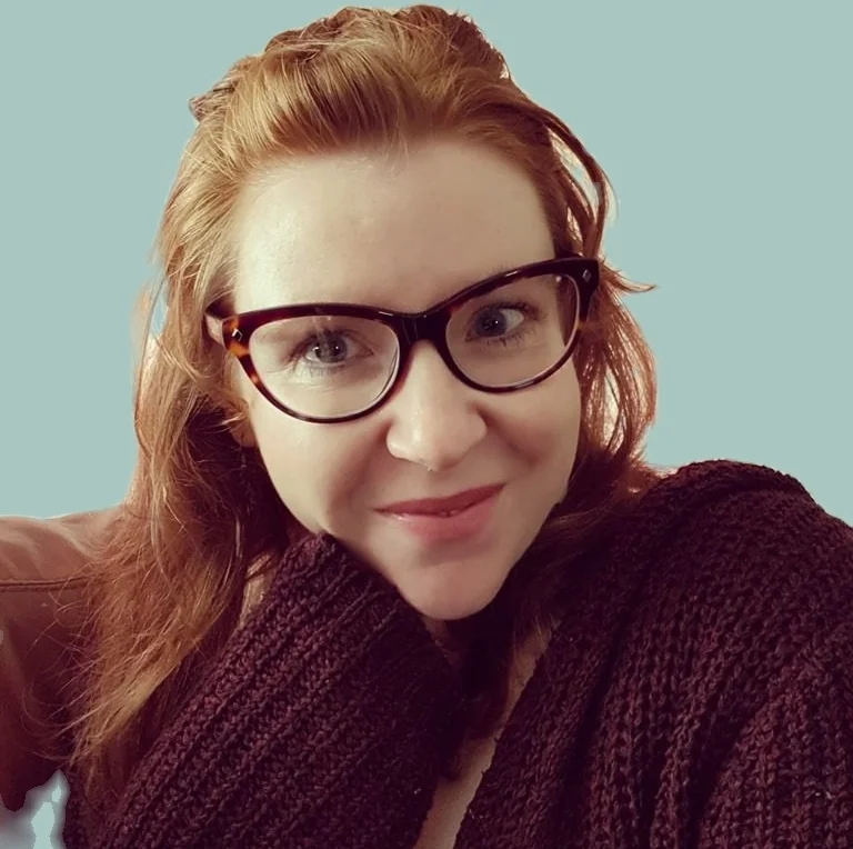 Kitty Black, a woman with red hair and glasses